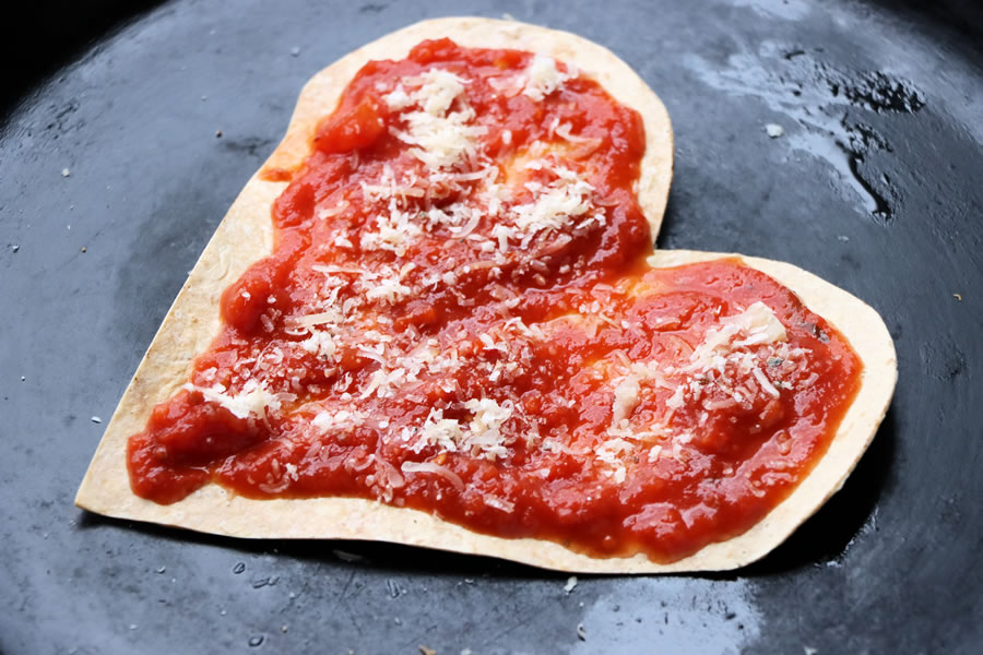 low carb heart shaped crust topped with sauce and parmesan cheese